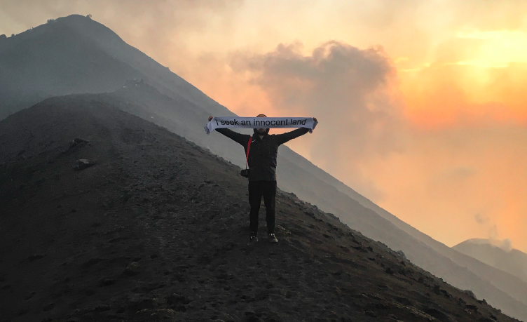 Simona Andrioletti and Riccardo Rudi, Chinese Whispers, ongoing since 2018, soccer scarves edition English/Hindi 30/30, © the artists, photographed on top of the Stromboli Volcano in 2019.